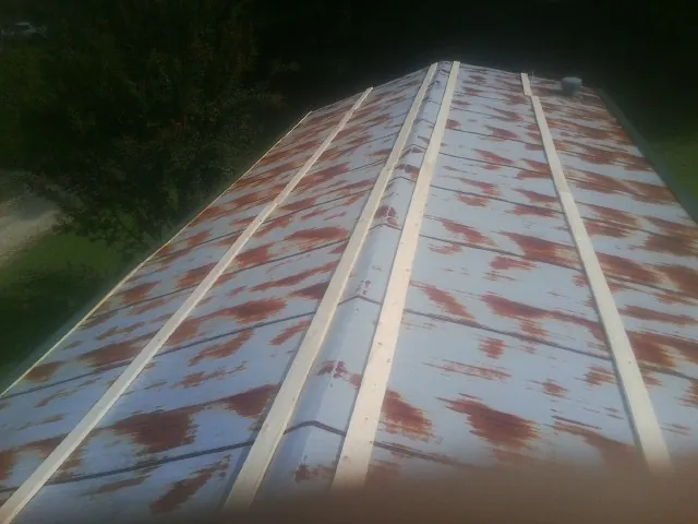 Rusted metal roof panels with new wood purlins before replacement — Storm Damage Roof Repair in Farmingville by Roofing Brothers