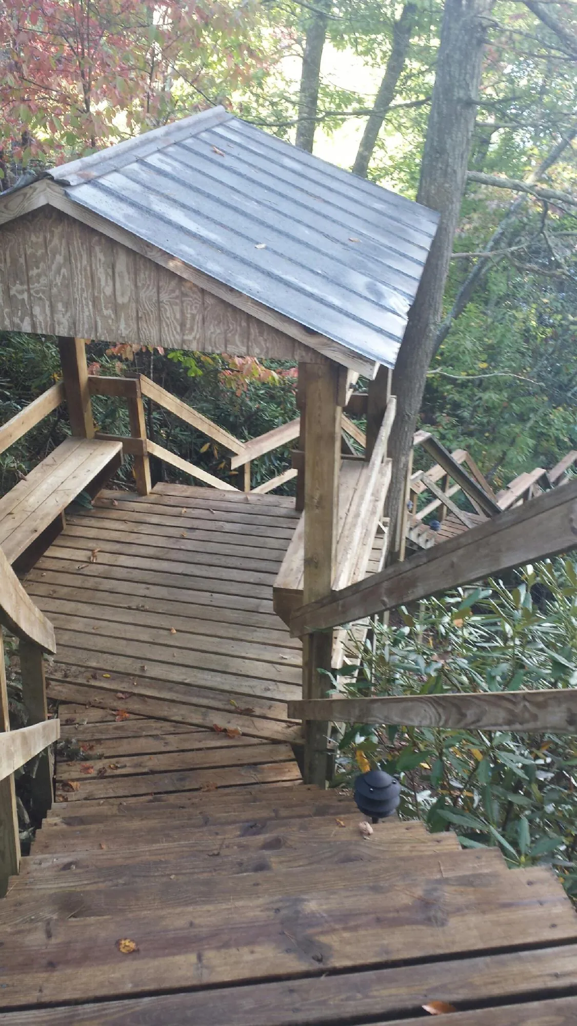 Metal roofed shelter over wooden steps on a wooded walkway — Skylight Repair & Installation work by our crew in Farmingville