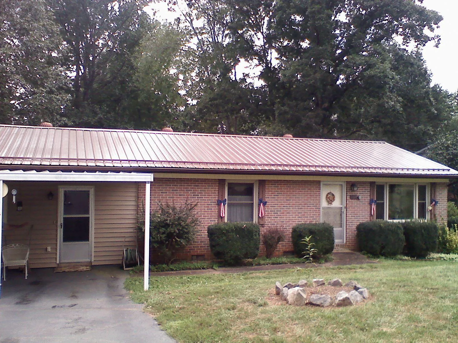 Bronze metal roof and carport on a brick ranch home — Roof Repair work by our crew in Farmingville